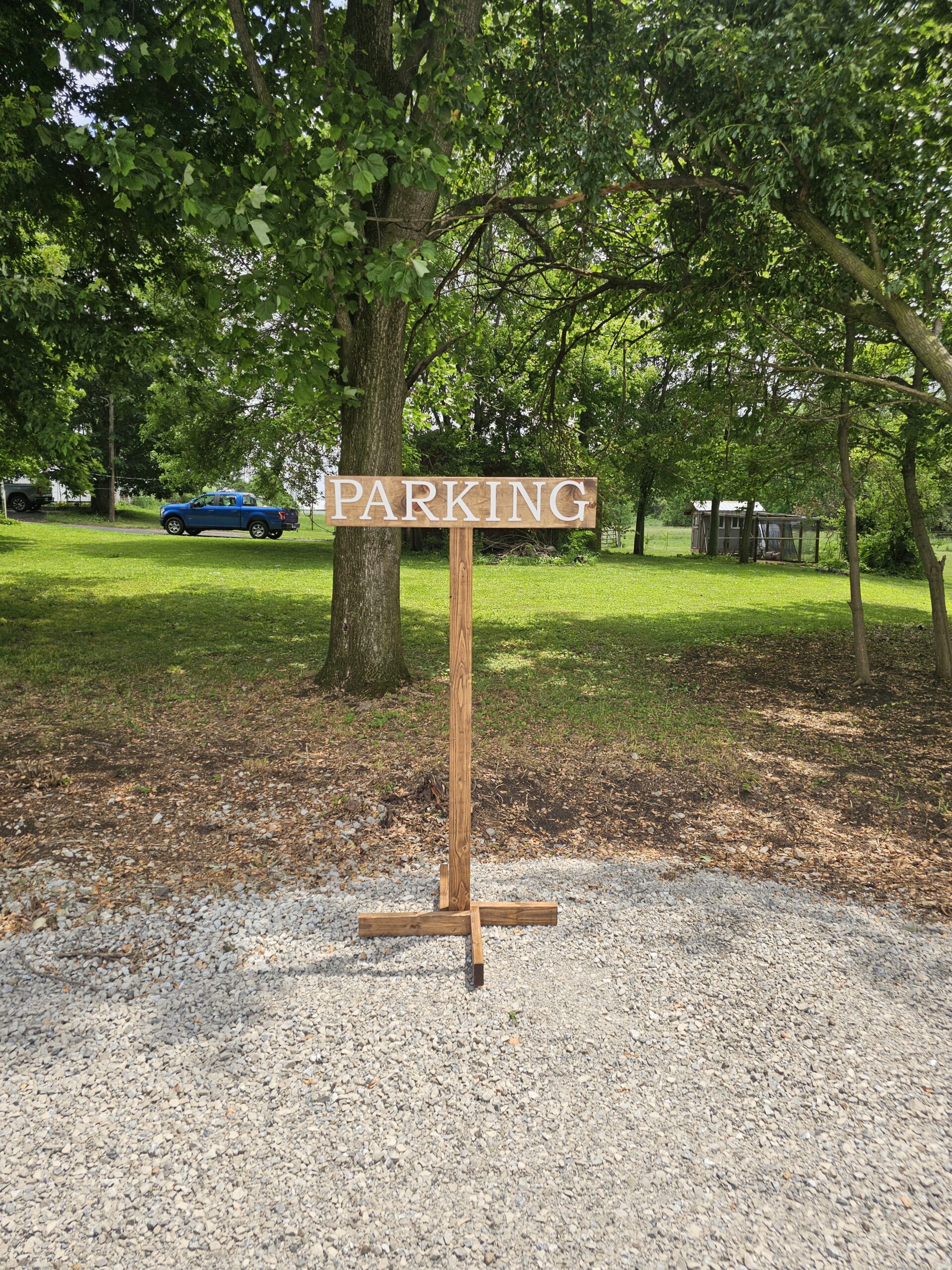 Wooden parking sign in gravel lot